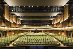 an empty auditorium with rows of seats and lights on either side of the stage,