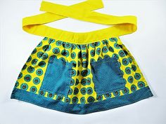 a child's dress made out of yellow and blue material with buttons on it