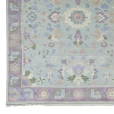 a blue rug with flowers and leaves on the bottom, in pastel colors against a white background