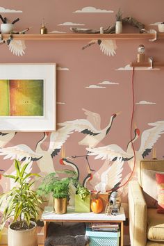 a living room filled with furniture and wallpaper covered in birds on it's walls