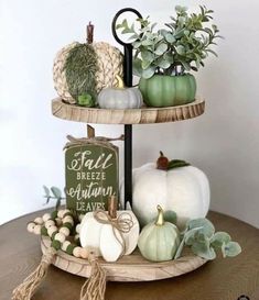 two tiered trays with pumpkins and greenery