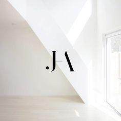 an empty room with the word j on it's wall next to a window