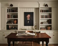 an open book sitting on top of a wooden table in front of bookshelves