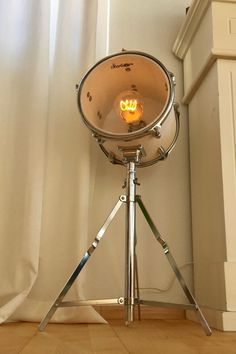 a tripod light sitting on top of a wooden floor