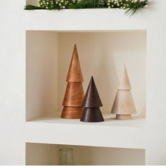 three wooden christmas trees sitting on top of a shelf