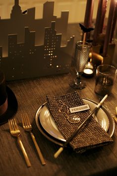 a place setting with silverware and napkins on a table in front of a cityscape