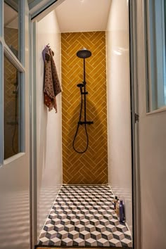 an open door leading to a bathroom with a tiled floor and yellow wall behind it