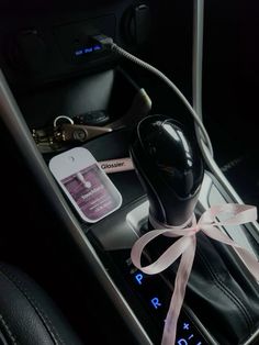 the interior of a car with an air freshener, phone and other items in it