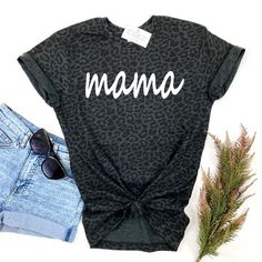 The coolest black leopard print tee! Choose from Mama or Mini or add both for a matching Mommy & Me set! Choose your Design (Mama or Mini), then Size, then Add to Cart. Repeat these steps for each shirt you would like to add. Professionally screen printed. Shirt color is Black Leopard. Print color is White. Mama is printed on a standard adult unisex tee made of 60% ringspun cotton/40% polyester. Fits true to size. Unisex sizing. We recommend ordering the same size you normally wear in an adult u Leopard Print T-shirt With Letter Print And Crew Neck, Family Matching Black Tops With Funny Print, Black Family Matching Tops With Funny Print, Black Tops With Funny Print For Family Matching, Trendy Cotton T-shirt In Leopard Print, Black Family Matching Tops With Text Print, Black Relaxed Fit Top With Name Print, Leopard Print Top With Letter Print For Summer, Cute Black Printed Tops