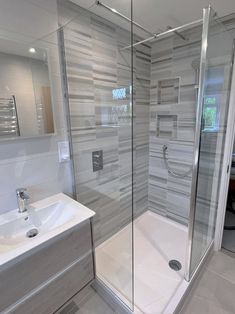 a bathroom with a walk in shower next to a sink