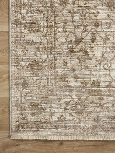 a beige and brown rug on top of a wooden floor