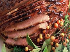 sliced meat on a plate with berries and herbs