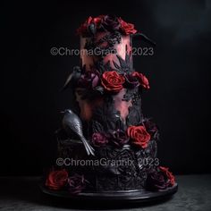 a three tiered cake with red roses and birds on the top, surrounded by black frosting