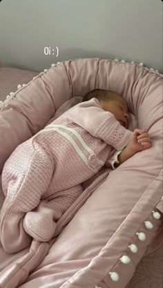 a baby is sleeping in a pink crib