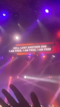 someone is holding their hand up in front of a large screen that says hell lost another one i am free, i am free