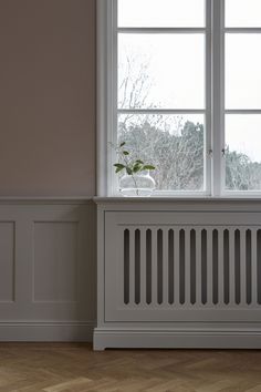 a white radiator sitting in front of a window next to a wooden floor