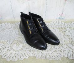 Cute 80s or 90s black leather ankle boots by Life Strides. These have a classic pointed almond toe and instead of laces in the front, they have black elastic horizontal straps with bronze metal on each side. The insole and insides feel a bit cushiony. These have some light wear on the sole, a small mark on one elastic strap and creasing in the leather, but overall they look good and are ready to wear!  Size marked: 6 M -- see measurements to ensure fit.  Measurements are in inches.  Length of insole: 9 1/4 Width at ball of foot: 3 Follow @lunarhovel on instagram for new items posted every week and sale announcements! International customers - I am not able to mark items as a gift on the customs form. You are responsible for all customs fees and being aware of your own country's rules and r Trad Goth, Punk Grunge, Black Leather Ankle Boots, Bronze Metal, Goth Punk, Leather Ankle Boots, Boot Shoes Women, Vintage Clothing, Bootie Boots