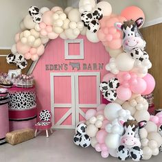 a pink barn decorated with balloons and animals