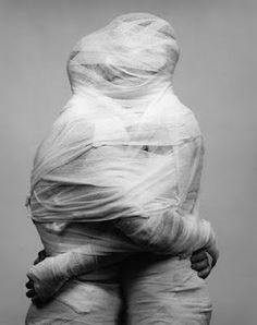 a black and white photo of a woman with her hair wrapped in plastic wraps