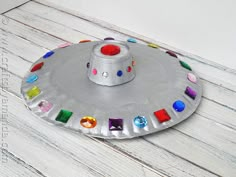 a paper plate that has some kind of hat on it with colored stones in the middle