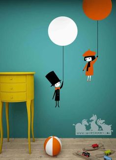 two children are playing with balloons in the air on a blue and green wallpapered room