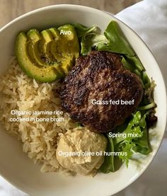 a white bowl filled with rice, meat and veggies next to an avocado