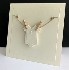 a white card with two baby ones hanging from it's sides