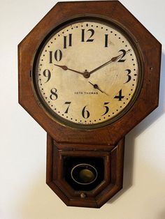 an old wooden clock hanging on the wall