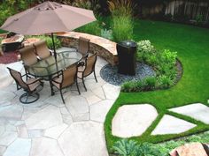 an outdoor patio with table, chairs and umbrella in the grass next to a fire pit