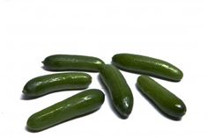 several green cucumbers on a white surface