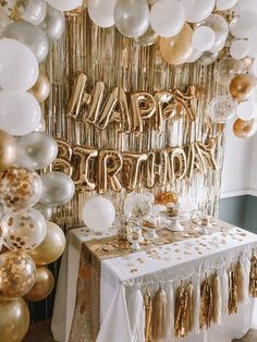 a birthday party with gold and white balloons