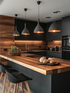 a kitchen with black cabinets and wooden counter tops, along with stools that match the hardwood flooring