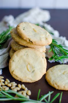 some cookies are stacked on top of each other with sprigs of rosemary next to them