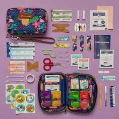 the contents of a travel kit are laid out on a purple surface, including scissors and other items