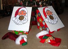 two cardboard santa clause boxes sitting in front of a christmas tree