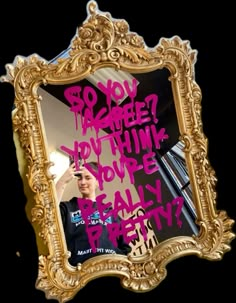 a gold framed mirror with pink writing on it