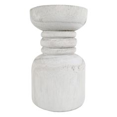 a white vase sitting on top of a table