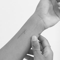 a woman's arm with a small tattoo on the wrist that says, i love you