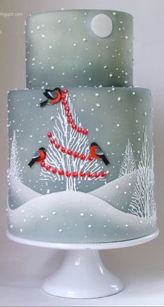 a three layer cake decorated with birds and snow