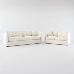 two white couches sitting next to each other on top of a white flooring