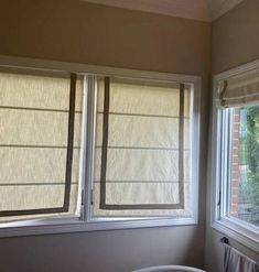 two windows with blind shades in a bedroom