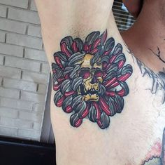 a man with a tattoo on his chest has a skull and flowers in the center