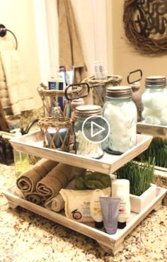 two tiered trays filled with items on top of a bathroom counter next to a mirror