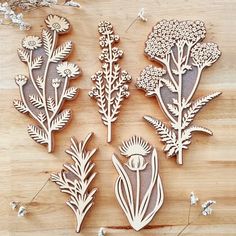 several wooden cutouts of flowers and plants on a table