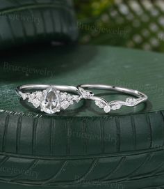 two wedding rings sitting on top of a green car tire with the word bridal jewelry