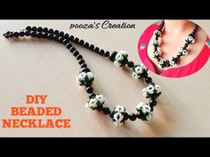 the beaded necklace is decorated with white and green flowers on black beads, along with an image of a woman's creation