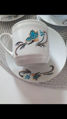 a white cup and saucer with blue butterflies on it