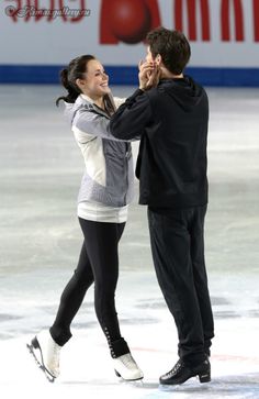 a man and woman skating on an ice rink