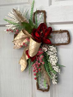 a cross decorated with flowers and greenery hangs on the front door to give it a rustic feel