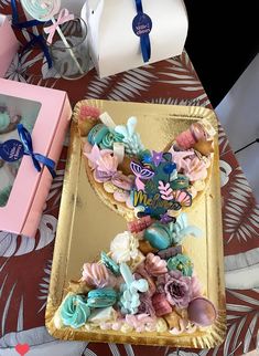 an elaborately decorated cookie in the shape of a heart sits on a gold tray